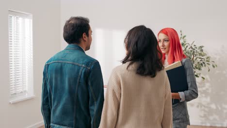 couple make appointment to see real estate agent pink-haired elegantly dressed owner invites them to look at newly renovated apartment in city center young people think about renting buying first flat