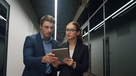 Colleagues-analyzing-tablet-report-go-business-center.-Pensive-workers-discuss