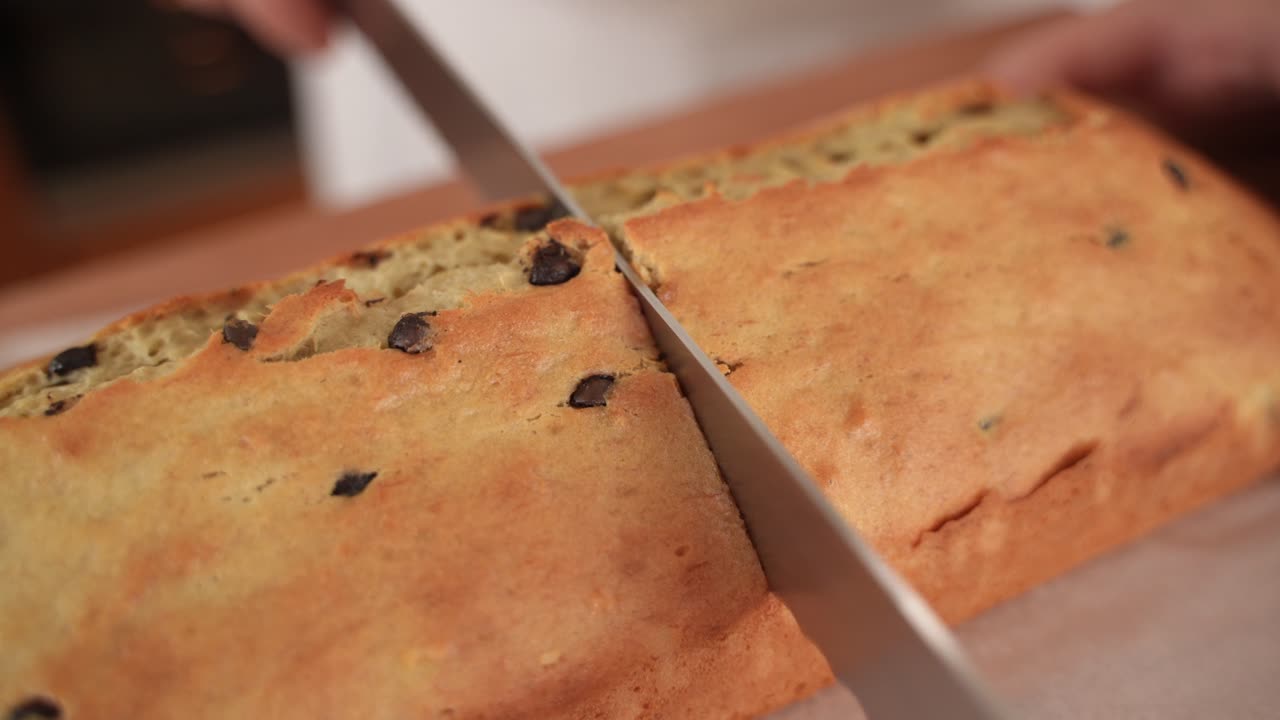 cortar pan con trocitos de chocolate por la mitad con un cuchillo, cerrar en cámara lenta