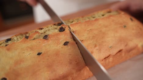 Cortar-Pan-Con-Trocitos-De-Chocolate-Por-La-Mitad-Con-Un-Cuchillo,-Cerrar-En-Cámara-Lenta