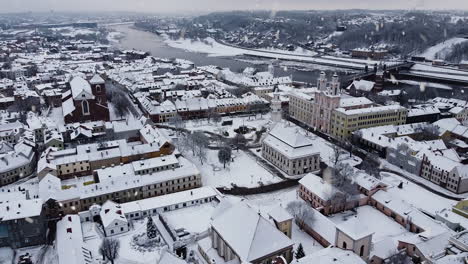 majestic snow-covered rooftops of kaunas old town and city hall while snowing