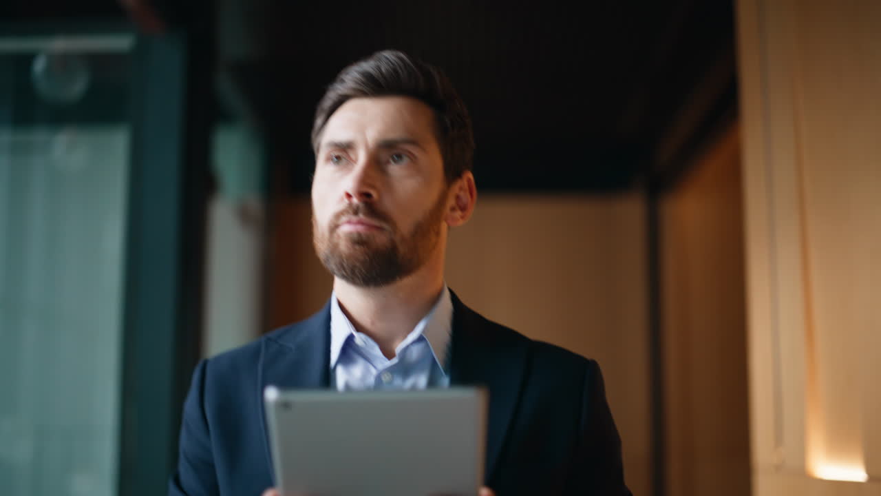 Elegant employee looking tablet walking office corridor closeup. Confident man