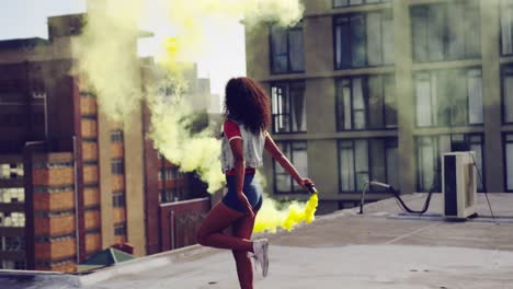 Fashionable-young-woman-on-urban-rooftop-using-a-smoke-grenade