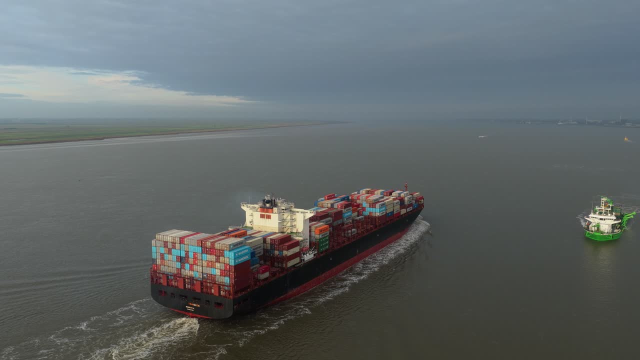 Cargo ship gliding over calm Elbe waters, aerial logistics view, Germany