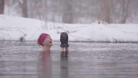 A-happy-female-ice-bather-looks-up-at-the-falling-snow-with-pure-joy