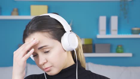una joven triste e infeliz escuchando música.