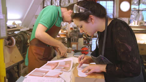 worker in bespoke shoemakers drawing template for last