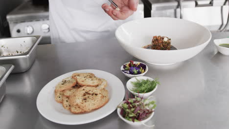 caucasian male chef decorating meal in kitchen, slow motion