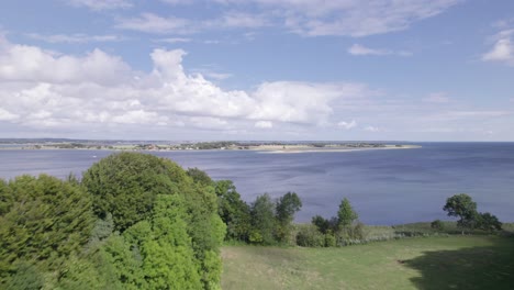 aerial view of the danish countryside the rolling hills and the sea - dolly shot