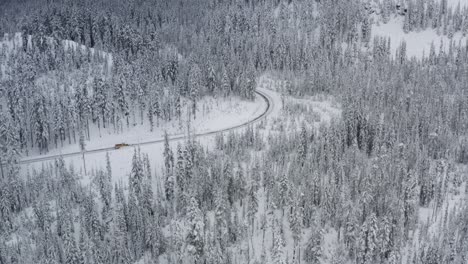 Ein-Schneepflug-Räumt-Eine-Verschneite-Straße-Inmitten-Eines-Winterwaldes