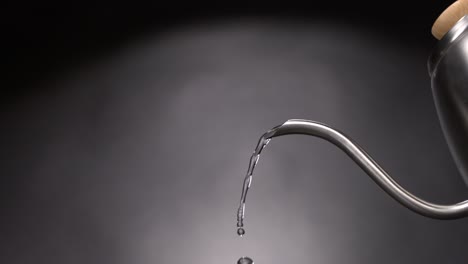 hot water drops coming out of a teapot in super slow motion