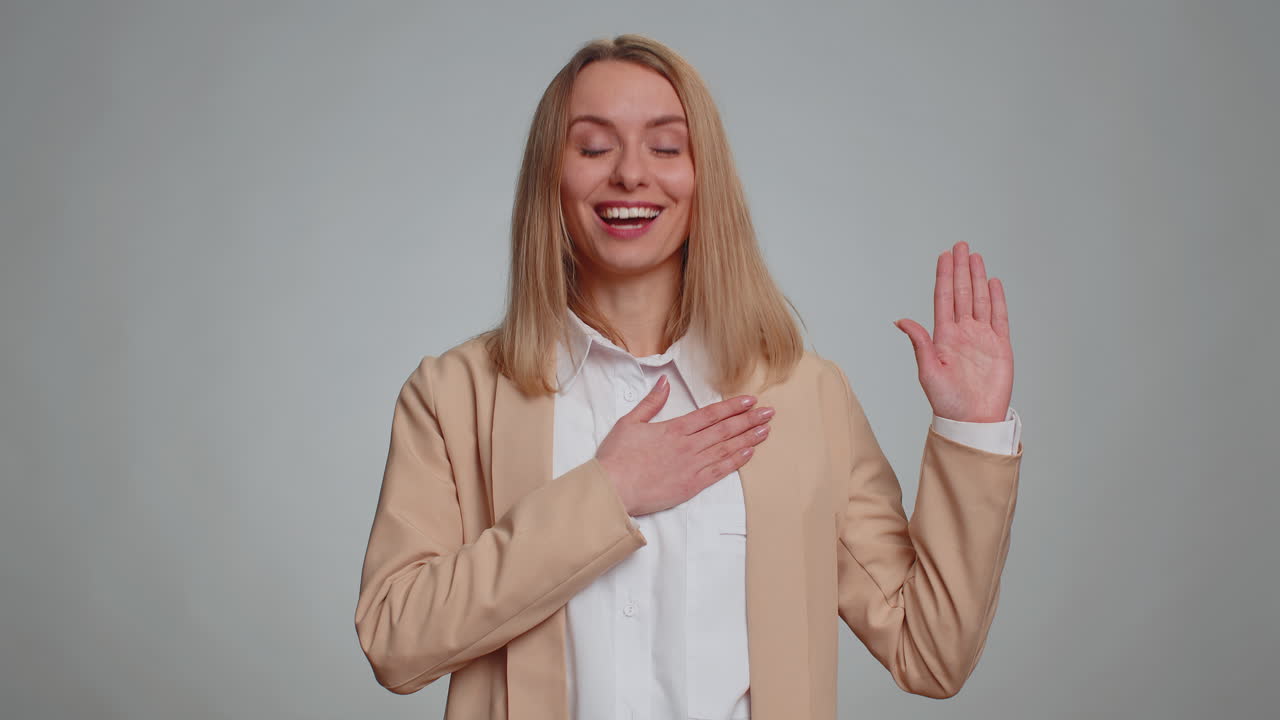 mujer levantando la mano para tomar el juramento prometiendo ser honesta y decir la verdad manteniendo la mano en el pecho
