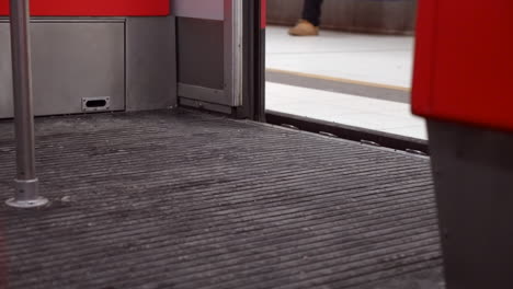 low angle: transit metro train door opens and commuter walks on, feet