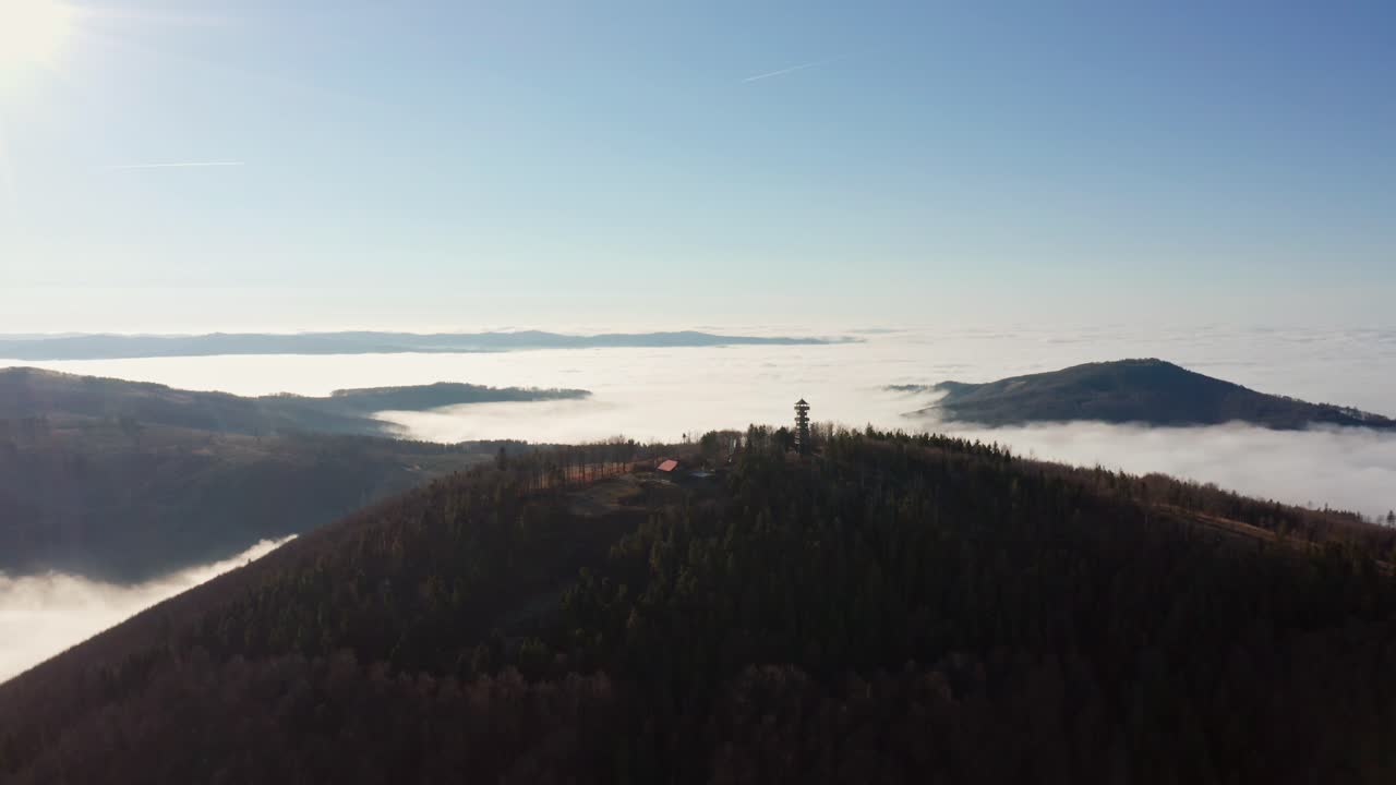 Zdjęcie z drona z góry na Beskidy z wieżą strażniczą i chatą we mgle