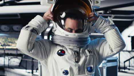 portrait of joyous cosmonaut putting helmet on, preparing for mission launh