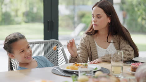 madre alimentando a su hija con la cena
