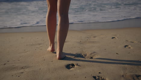 Chica-Caminando-Hacia-El-Mar-Con-Una-Ola-Entrante-En-Cámara-Lenta