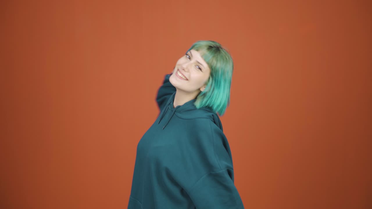 행복한 젊은 여자가 춤을 추고 있습니다.