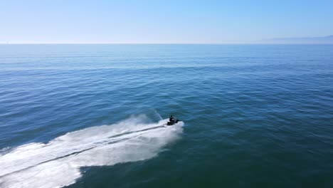 an excellent aerial shot of a man jet skiing on clear water 1