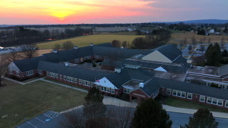 Red-brick-American-school-building,-aerial-establishing-shot