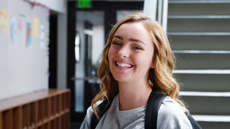 Portrait-Of-Female-High-School-Student-Standing-By-Stairs-In-College-Building