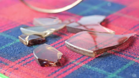 close-up of broken eyeglass lenses on red plaid fabric