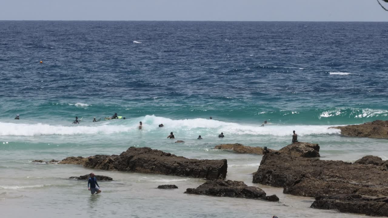 서퍼 들 과 해변 을 즐기는 사람 들 이 바다 파도 를 즐기고 있다