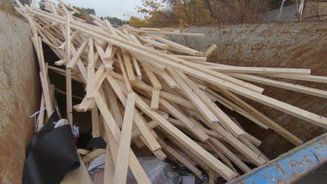 a big pile of wood in a container on a construction site