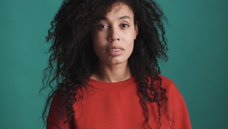 una mujer afroamericana relajada sobre un fondo azul.