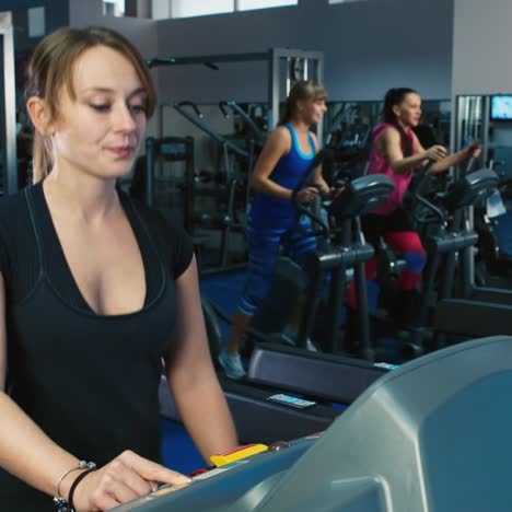 Frau-Trainiert-Im-Fitnessstudio,-Während-Andere-Leute-Im-Hintergrund-Trainieren