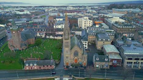 reverso ascendiendo por encima del antiguo cementerio de la iglesia alta revelando más de la ciudad de inverness