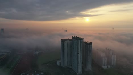 sunrise over foggy cityscape with high-rise buildings