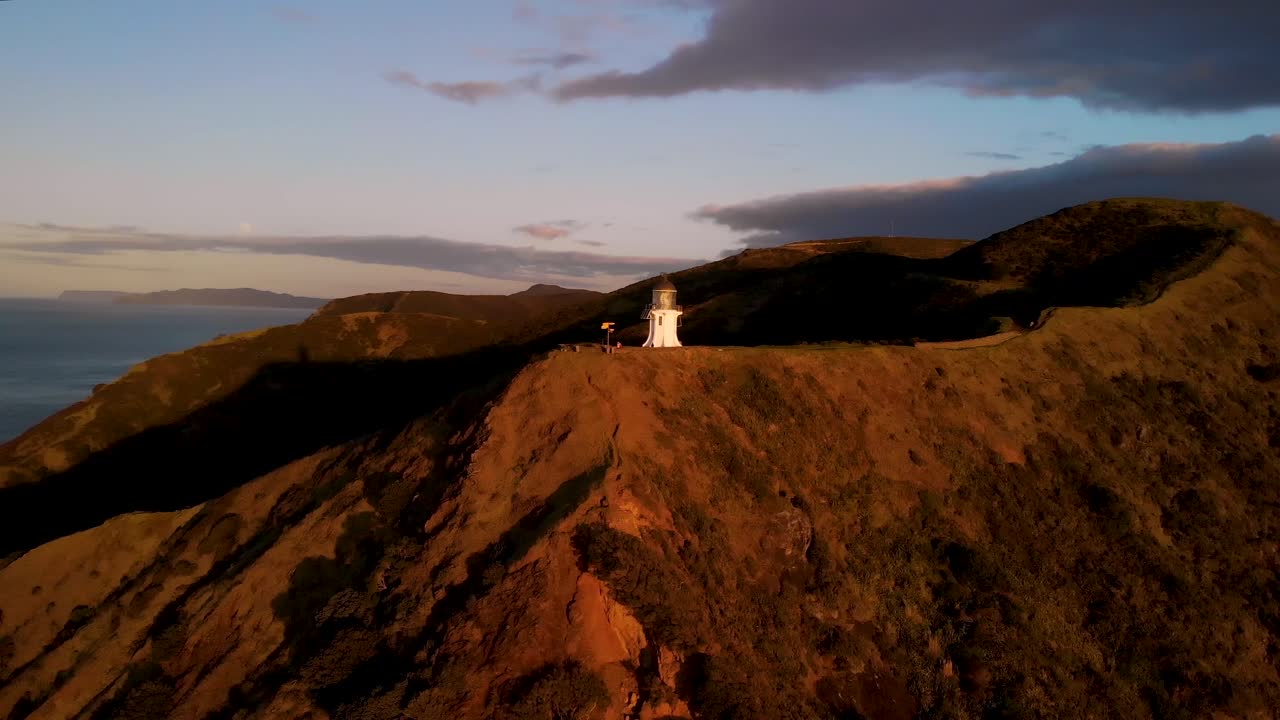 faro de cape reinga en la punta de la península de aupuri durante la hora dorada en la isla norte de nueva zelanda