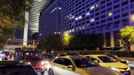 congestion along the sidewalk in beijing, with a striking purple-lit building in the distance