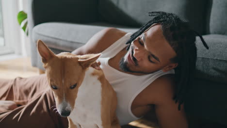 friendly guy cuddling pet living room closeup. young man stroking adorable dog