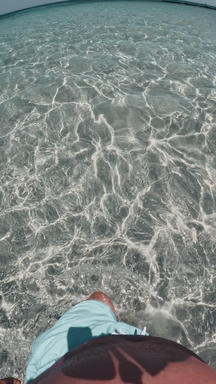Man Walking In Shallow Sea Water In Elafonisi, Crete, Greece - Vertical Shot