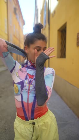 stylish woman in colorful clothing in a city alley