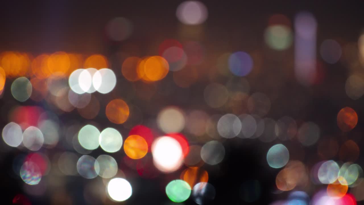 LA: Downtown LA skyscrapers focus pull bokeh to reveal skyline, with searchlights in the foreground, shot from Hollywood Hills - Los Angeles California, USA