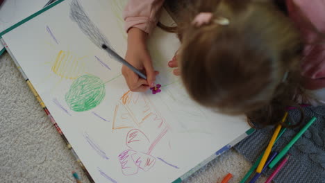 unknown girl lying floor with colored pencils