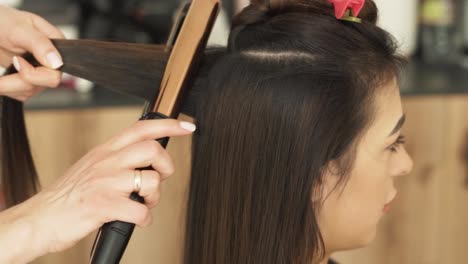 Retrato-De-Una-Hermosa-Joven-Caucásica-Con-El-Cabello-Alisado-Y-Rizado-Con-Un-Rizador-Para-Darle-Volumen-En-Un-Salón-De-Belleza-Y-Salud