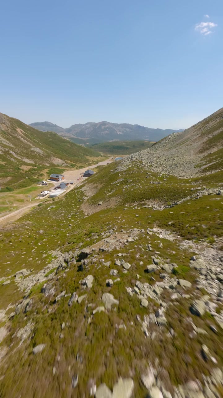 Video verticale dinamico cattura il volo di un drone FPV che si libra sopra le aspre cime e i verdi pendii di San Isidro nei monti Cantabrici, Asturie. Luce diurna intensa, riprese aeree nitide, ideale per dispositivi mobili.