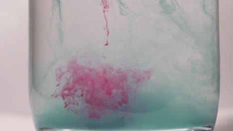 red paint dissolving in water shot in slow motion with sony a7iii.