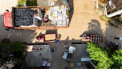 top-down aerial view of people loading kiwis onto a truck in zhouzhi county, shaanxi province, china.