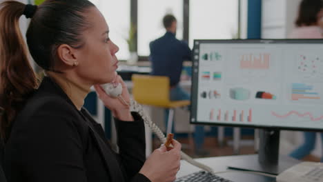 Closeup-of-businesswoman-sitting-at-desk-in-front-of-computer-eating-pizza-slice