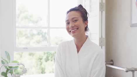 Portrait-of-happy-asian-woman-smiling-in-bathroom,-in-slow-motion