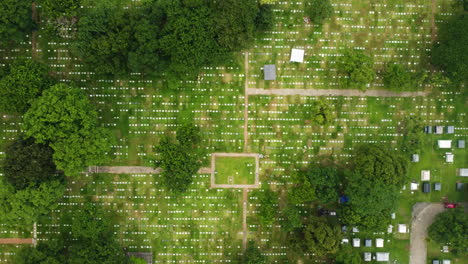 birdseye drone shot descending above graves at the manila memorial park, philippines