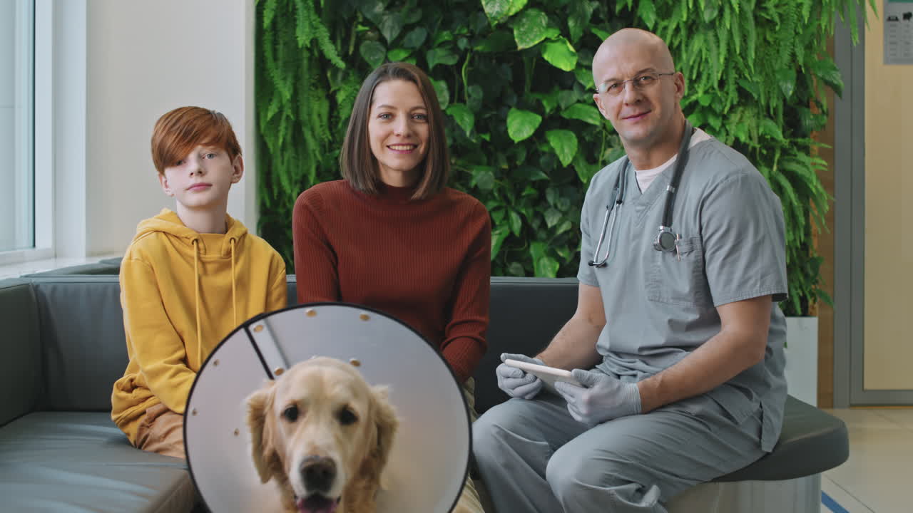 Smiling Vet Doctor With Dog And Its Owners