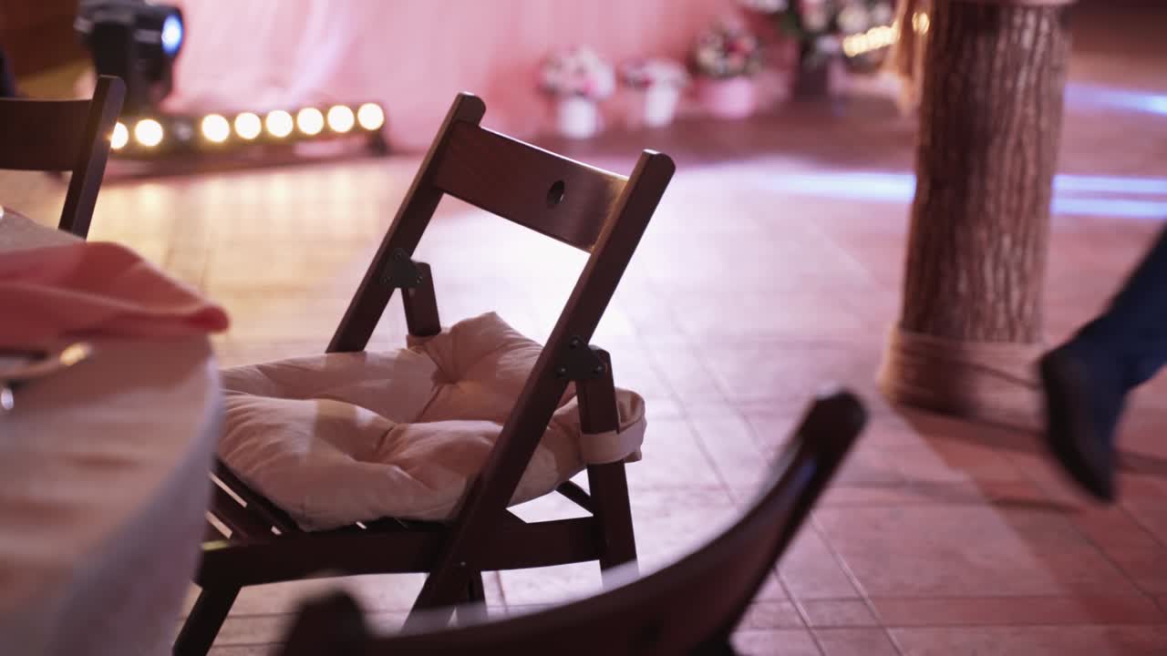 silla de madera con cojín suave se encuentra en la sala de banquetes con una hermosa luz de fondo.