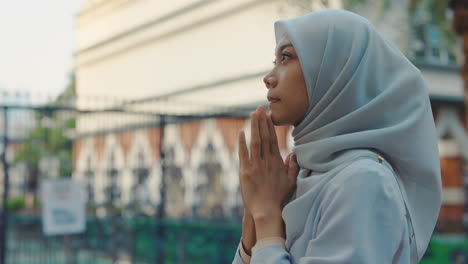 muslim woman in hijab praying