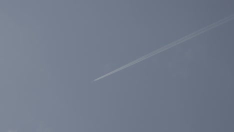 white smoke from a commercial plane in the sky